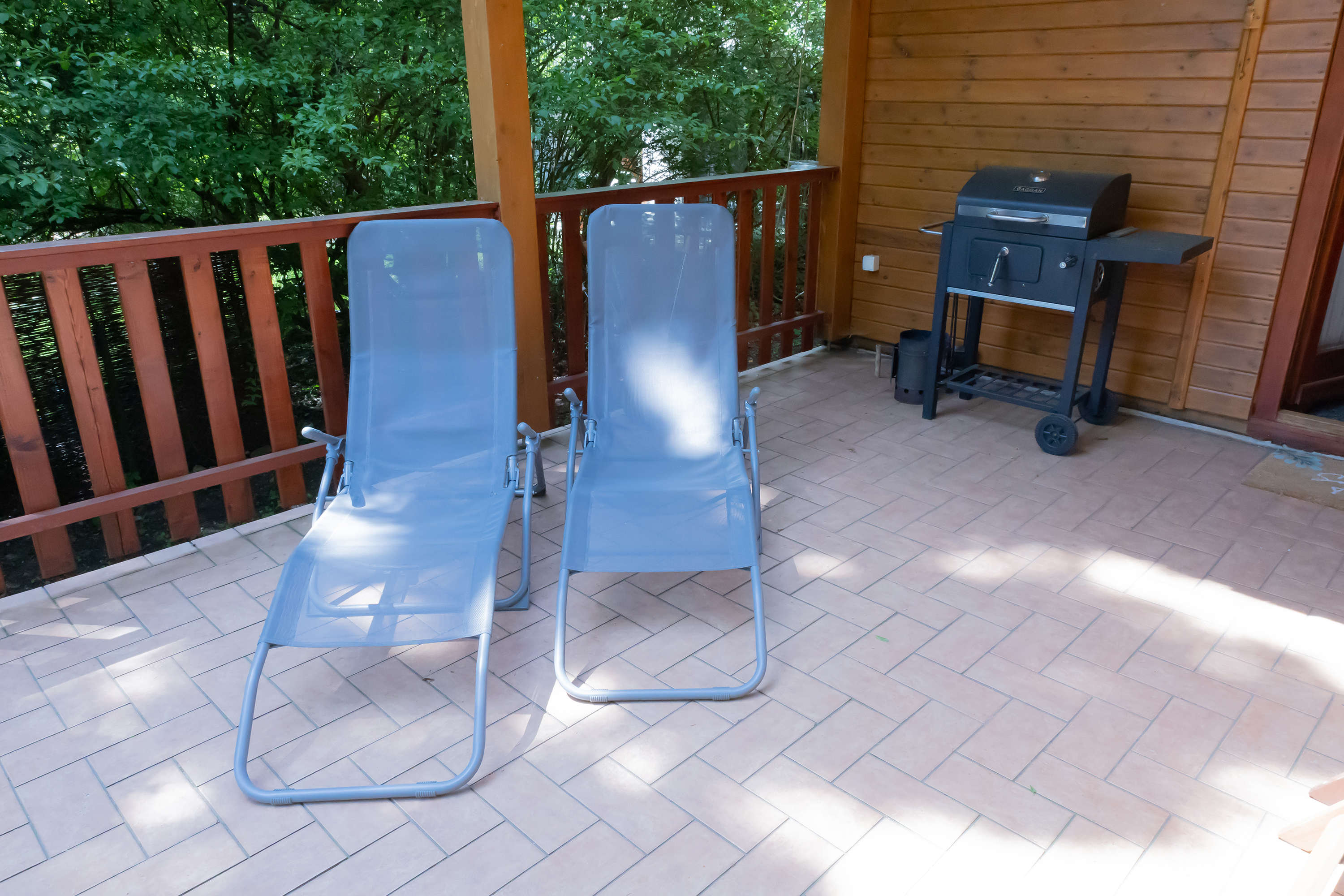 Napozóágyak, grillel a háttérben